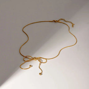 Colar de Laço, Colar de Laço Dourado, Colar de Laço Feminino, Colar de Laço Elegante, Colar de Laço Minimalista, Colar de Laço com Pingente, Colar de Laço para Noivas, Colar de Laço para Presente, Colar de Laço Luxuoso, Colar de Laço com Design Moderno, Colar de Laço Estiloso, Colar de Laço Delicado